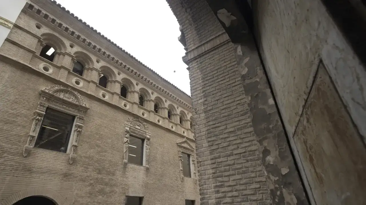 Fachada de la casa de los Morlanes con sus arcos y detalles ornamentales, vista desde un pasaje.