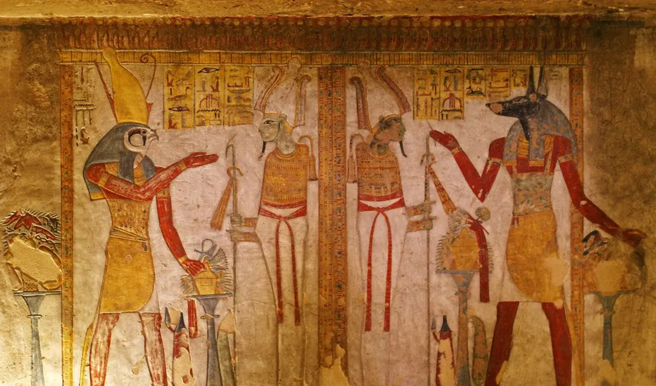 En egyptisk gud med falkhuvud, tv&aring; figurer med djurhuvuden och hieroglyfer p&aring; en v&auml;ggm&aring;lning.