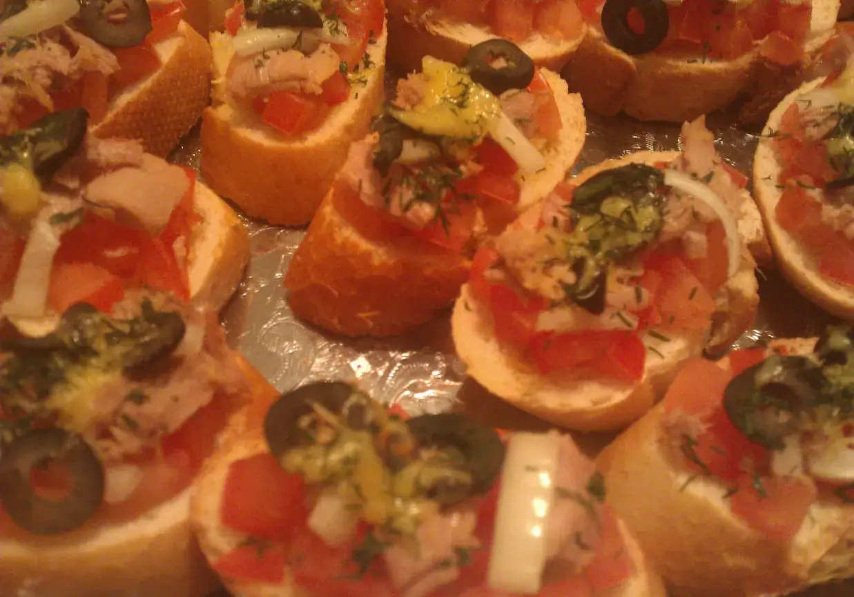 Bruschetta z tuńczykiem: chrupiące kromki bagietki z pomidorami, tuńczykiem, oliwkami i ziołami. Idealna przekąska na imprezę.