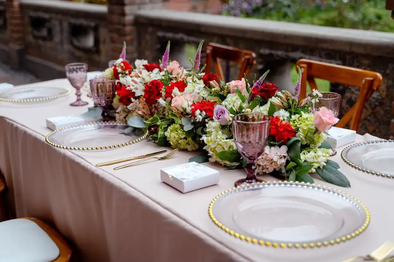 Elegante centro de mesa floral y vajilla dorada, perfectas ideas para una boda diferente y romántica.