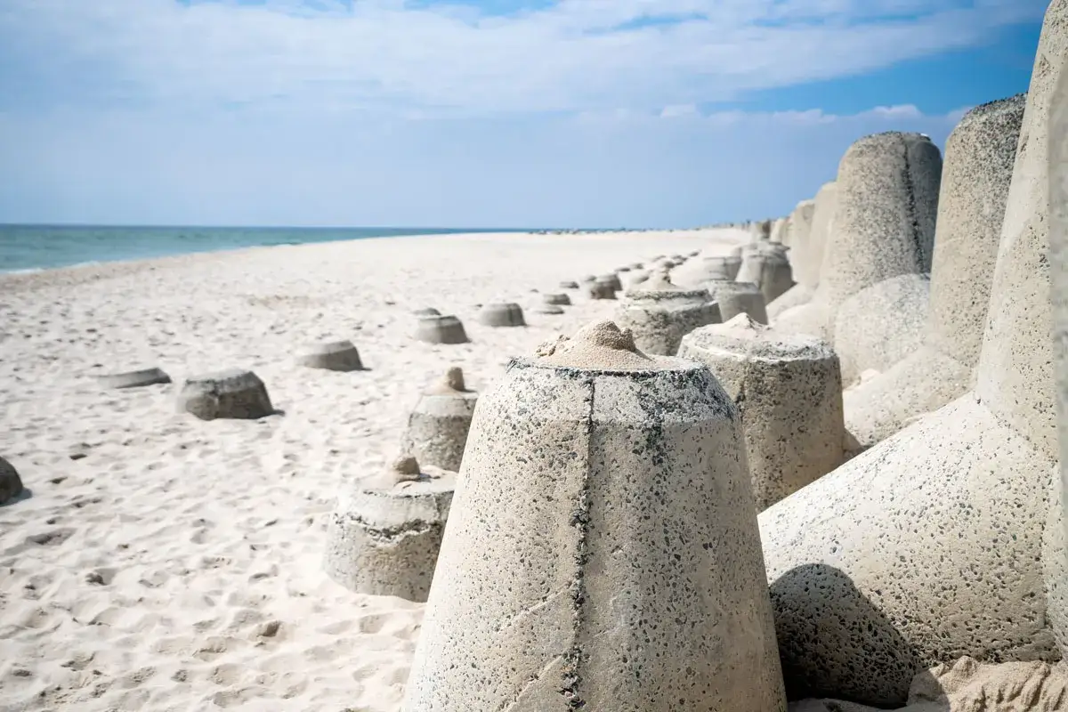 Betonsteine am Strand von Sylt, ein ungewöhnliches Motiv für Ausflugsziele Sylt. Der weite Sandstrand und das Meer im Hintergrund laden zum Entdecken ein.