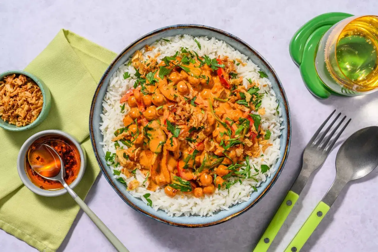 En sk&aring;l med fluffigt ris toppad med en kr&auml;mig kik&auml;rtscurry med paprika och toppad med krispig l&ouml;k och f&auml;rsk persilja. En h&auml;rlig thai mat-upplevelse.