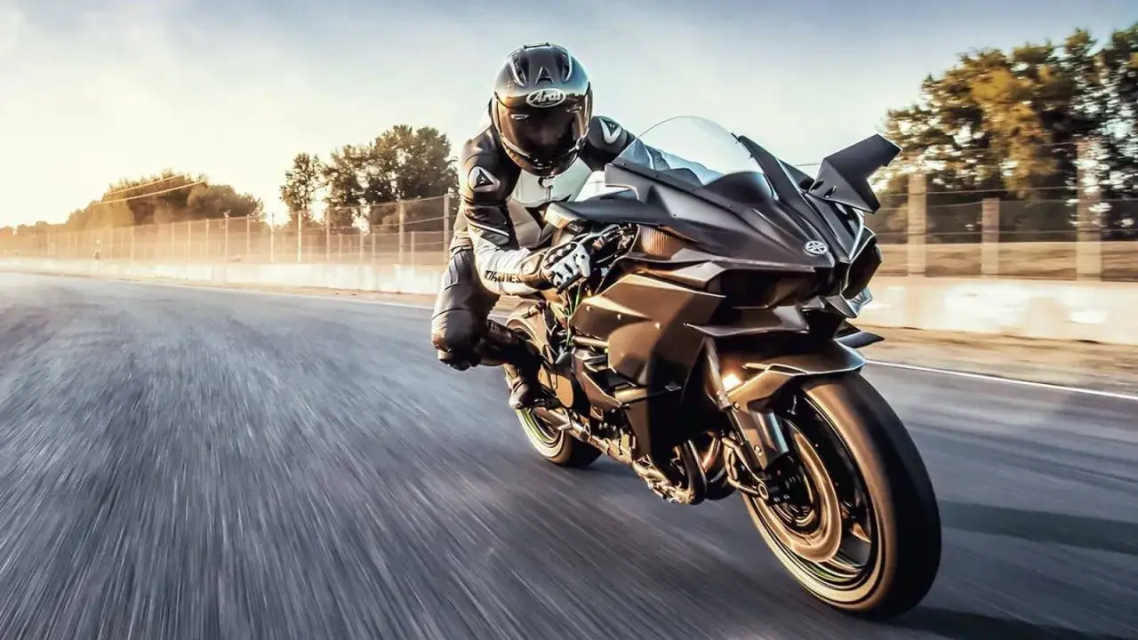 Motocyklista w kombinezonie pędzi na Kawasaki H2R, pokazując niesamowite kawasaki h2r przyspieszenie 0-100.