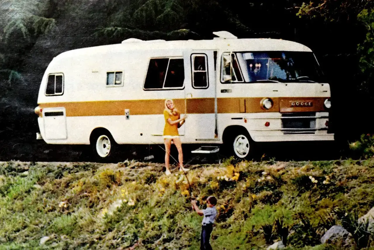Un couple profite d'une partie de pêche près de leur camping-car américain vintage Dodge, prêt pour l'aventure.