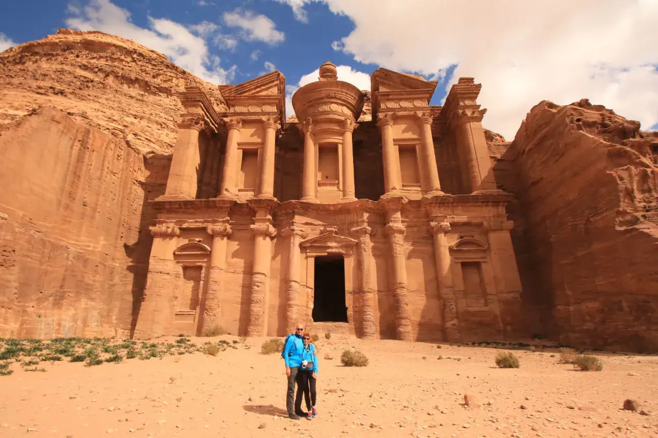 Para turystów przed monumentalnym miastem w skale w Jordanii.