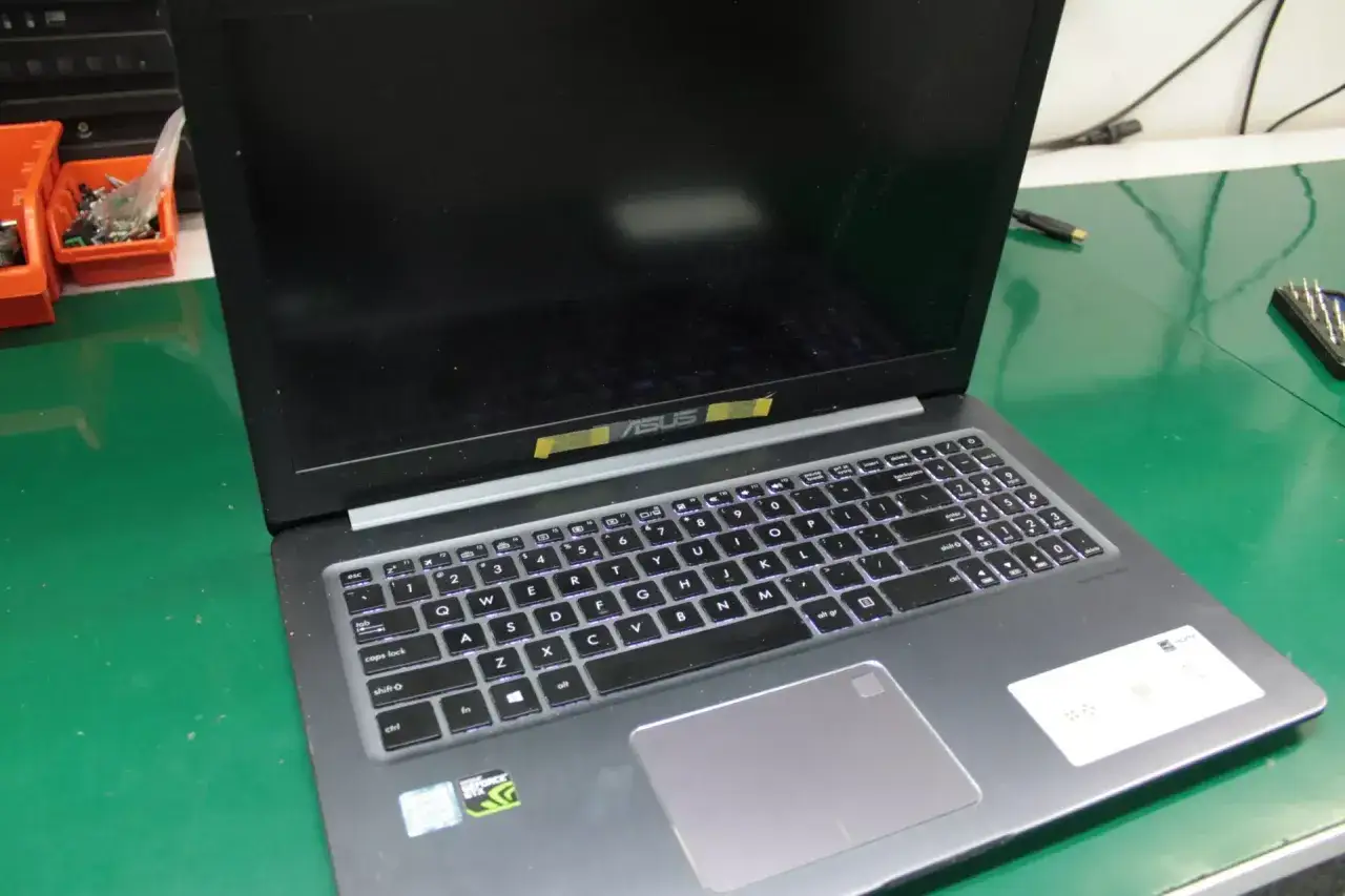 osoba naprawiająca laptopa czarny ekran