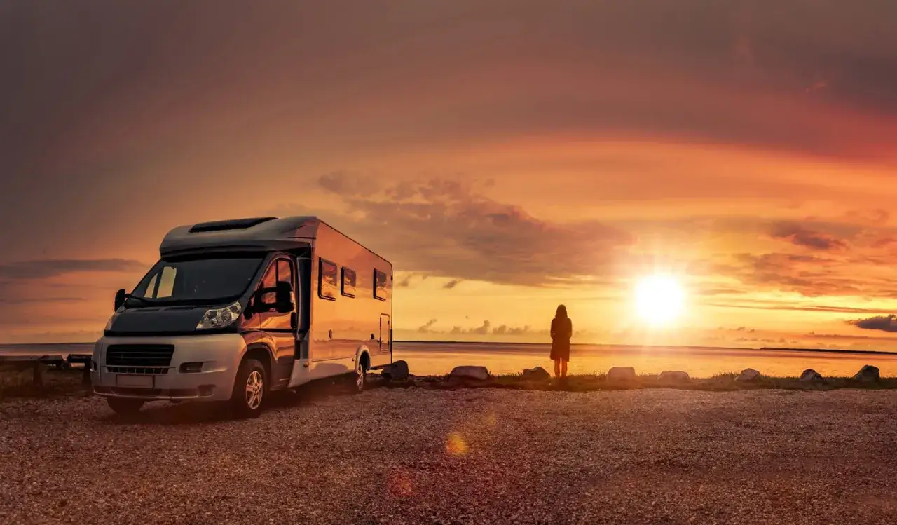 Wohnmobil am Meer bei Sonnenuntergang, ein Mensch blickt auf das Wasser. Ein echtes Naturwunder Deutschland.
