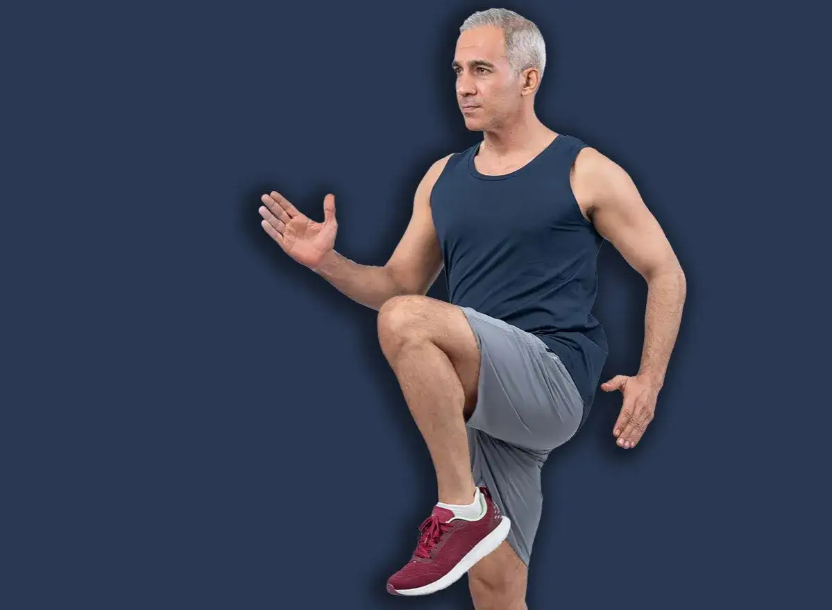 Mann mit grauem Haar macht Kniehebelauf. Ein Beispiel f&uuml;r erfolgreiche gewichtsabnahme im alter durch Sport.