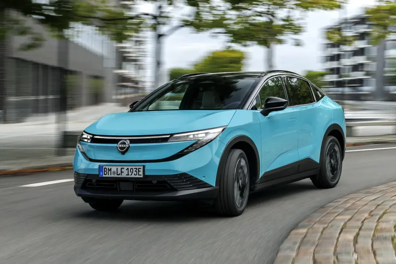La Nissan Leaf 2026, in un vivace azzurro, sfreccia su una strada urbana.