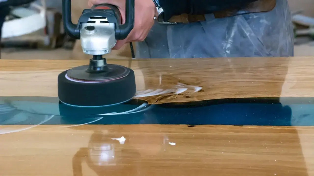 Proceso de como pulir resina epoxi en una mesa de madera. La pulidora crea espuma al trabajar la superficie.