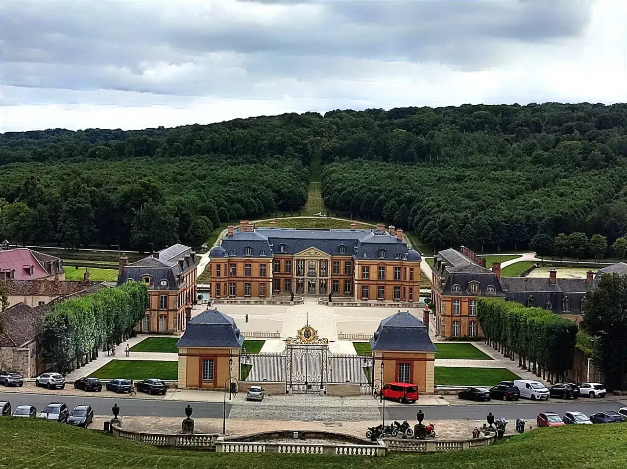 Vue a&eacute;rienne d'un ch&acirc;teau majestueux, entour&eacute; de jardins et d'une for&ecirc;t dense, &eacute;voquant la beaut&eacute; de la vall&eacute;e de Chevreuse.