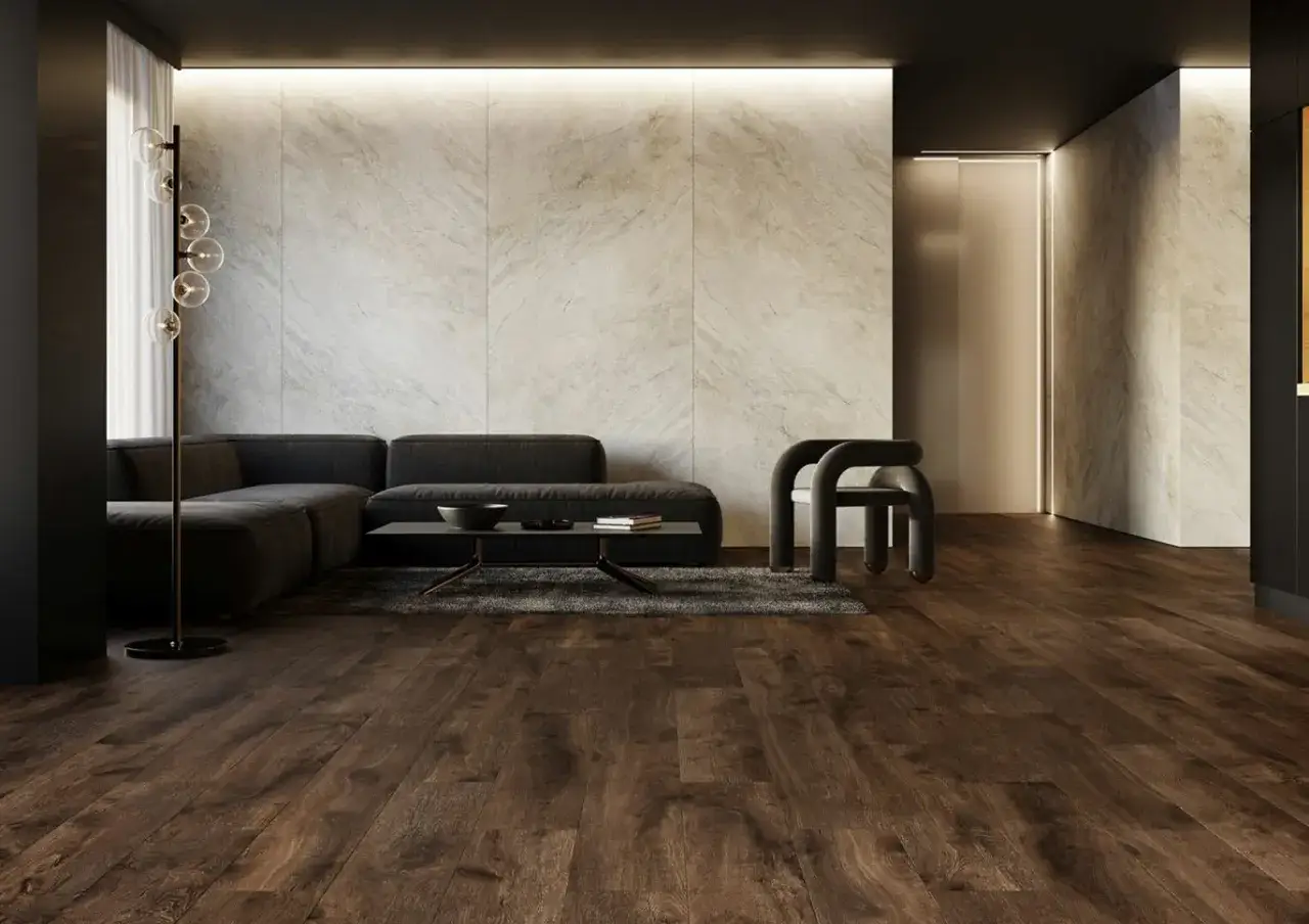 Nowoczesne płytki w salonie aranżacje: ciemna sofa, designerski fotel i kamienna ściana tworzą elegancką przestrzeń.