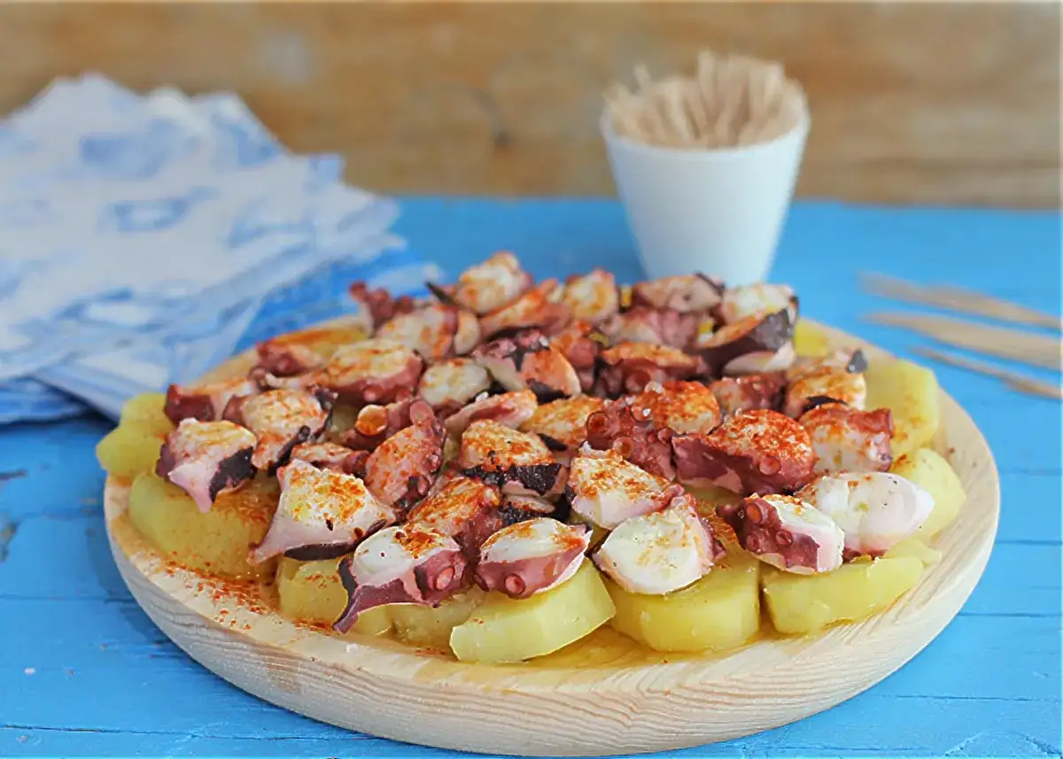 Pulpo con cachelos, un plato gallego tradicional, servido en una tabla de madera.