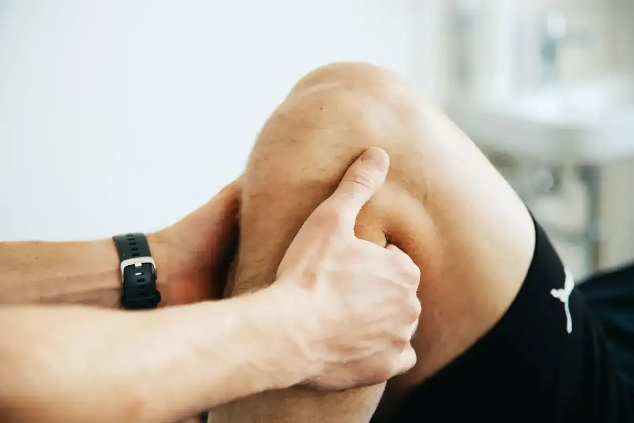 Physiotherapeut untersucht Knie auf Schwellung nach Kreuzbandriss.