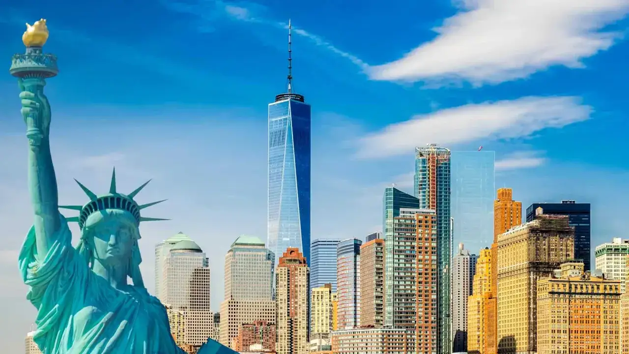 Freiheitsstatue und Skyline von New York City. Ein Muss, was man in New York gesehen haben muss, mit dem One World Trade Center im Hintergrund.