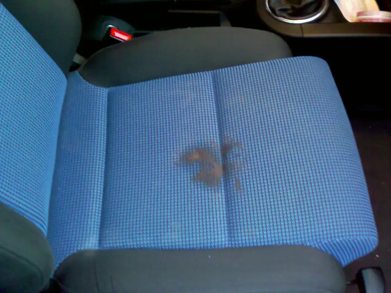 Flecken auf blauem Autositz. Informieren Sie sich über die autositze reinigen kosten, um den Fleck zu entfernen.