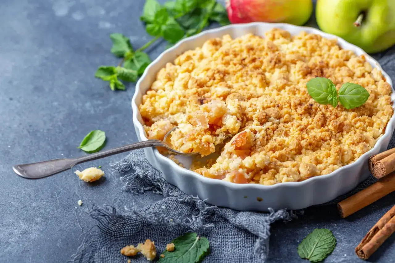 Un délicieux pâte à crumble aux pommes, garni de menthe fraîche et de bâtons de cannelle.