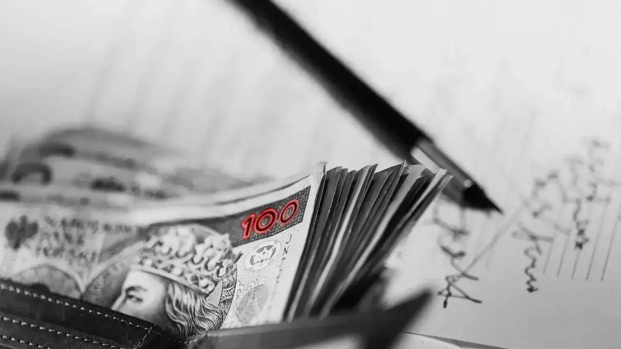 Stos banknot&oacute;w 100 zł w portfelu, obok długopis i dokumenty. Czy to op&oacute;źnienie w płatnościach, czy celowa zwłoka?