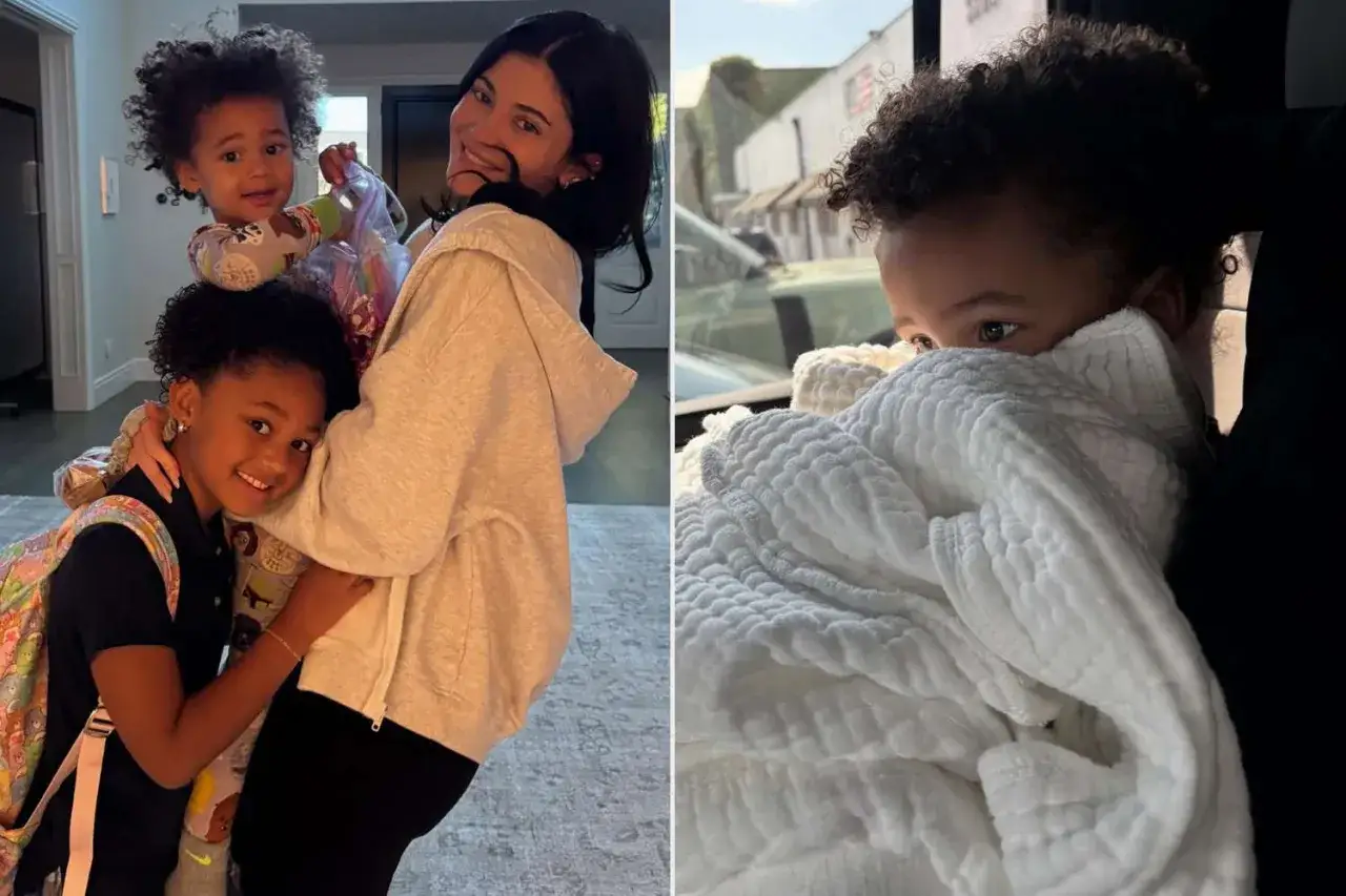 Kylie Jenner z dwójką swoich dzieci. Starsza córka przytula się do mamy, a maluch w białym kocyku wygląda zza niego.