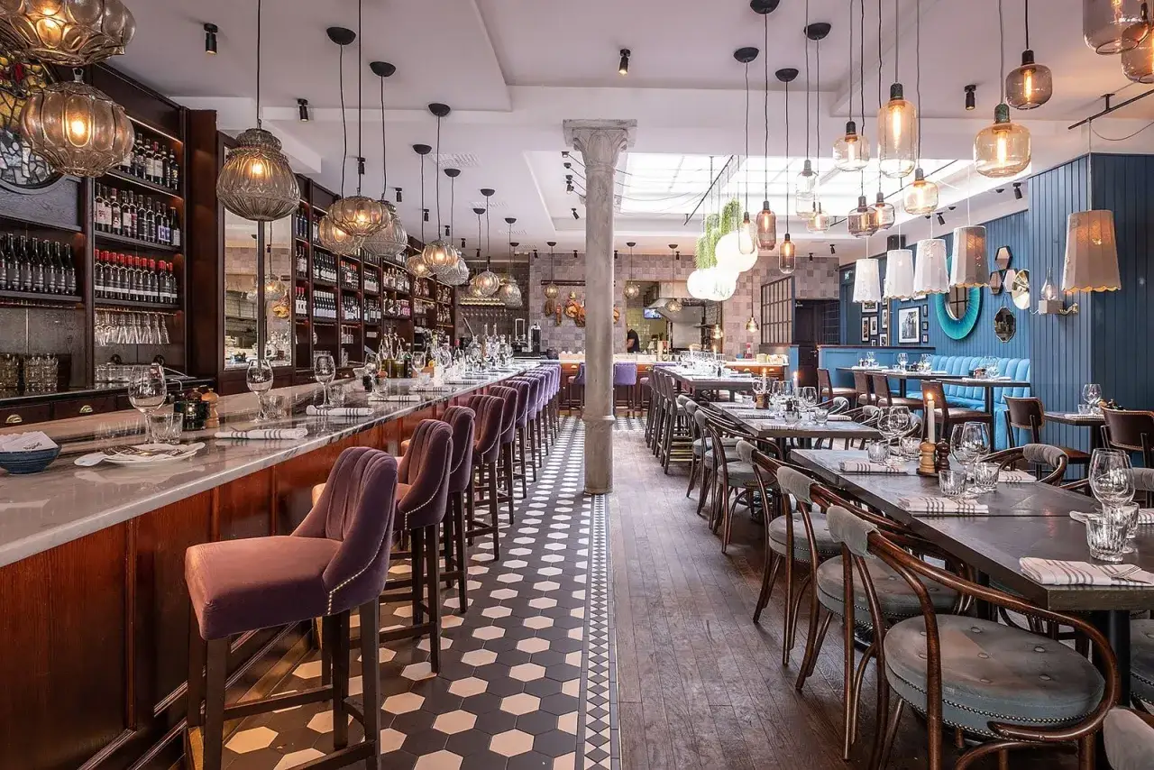 Elegant restaurang med bardisk, sammetsstolar och bord dukade för middag. Läs gärna sorellina recensioner för att få en uppfattning om maten.