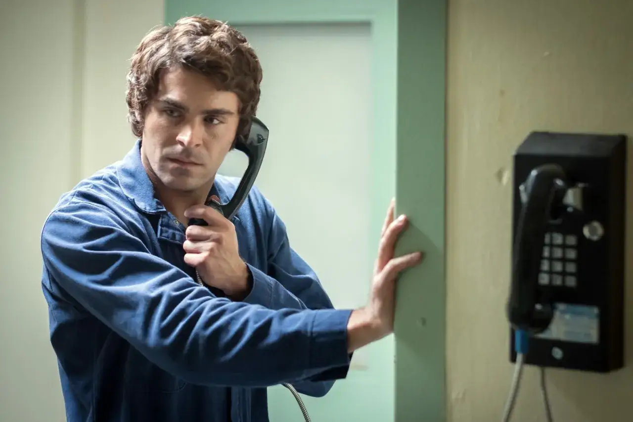 Zac Efron som Ted Bundy i f&auml;ngelset, talar i telefon.