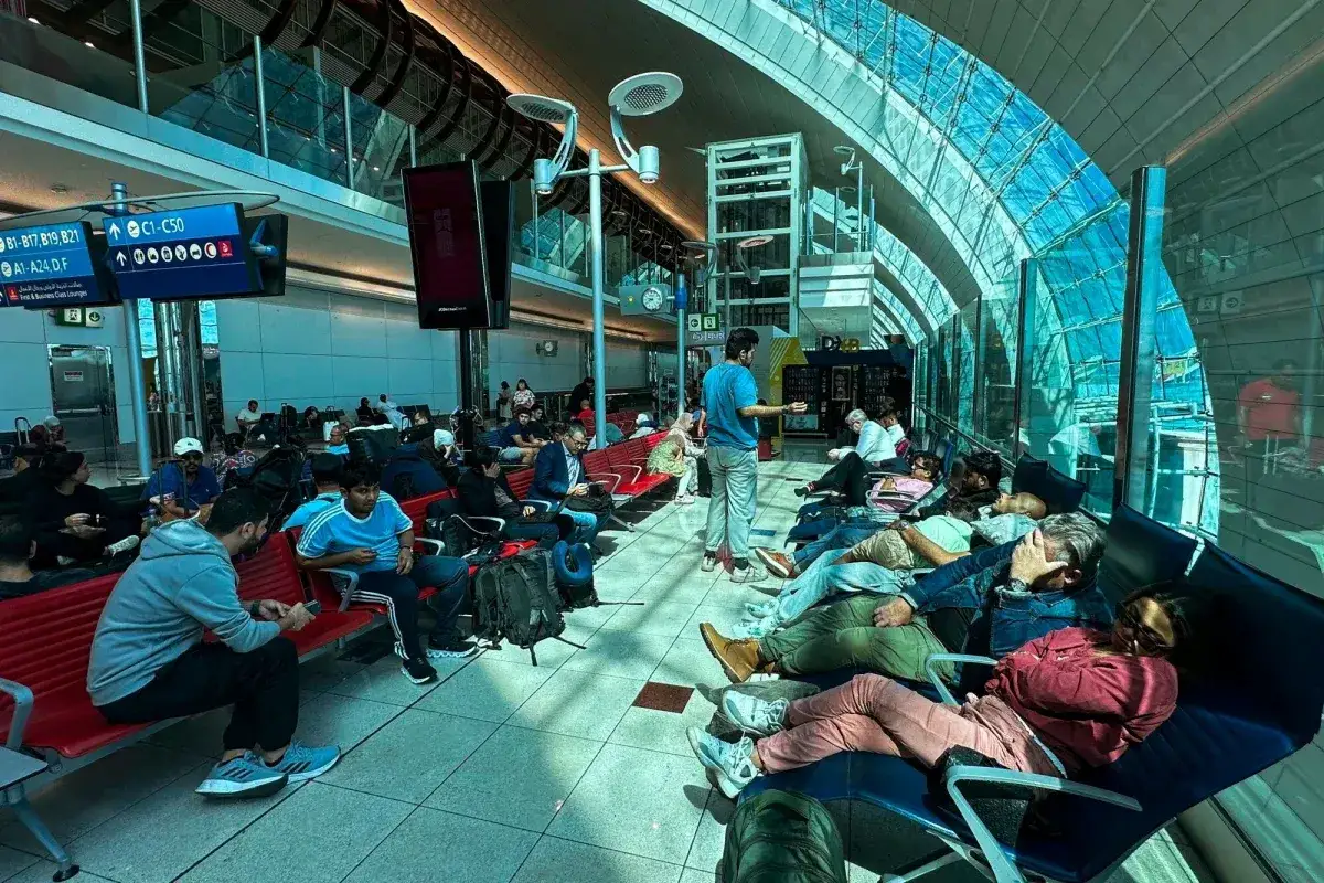 Ludzie odpoczywają na ławkach w poczekalni lotniska Abu Dhabi, czekając na swoje loty.