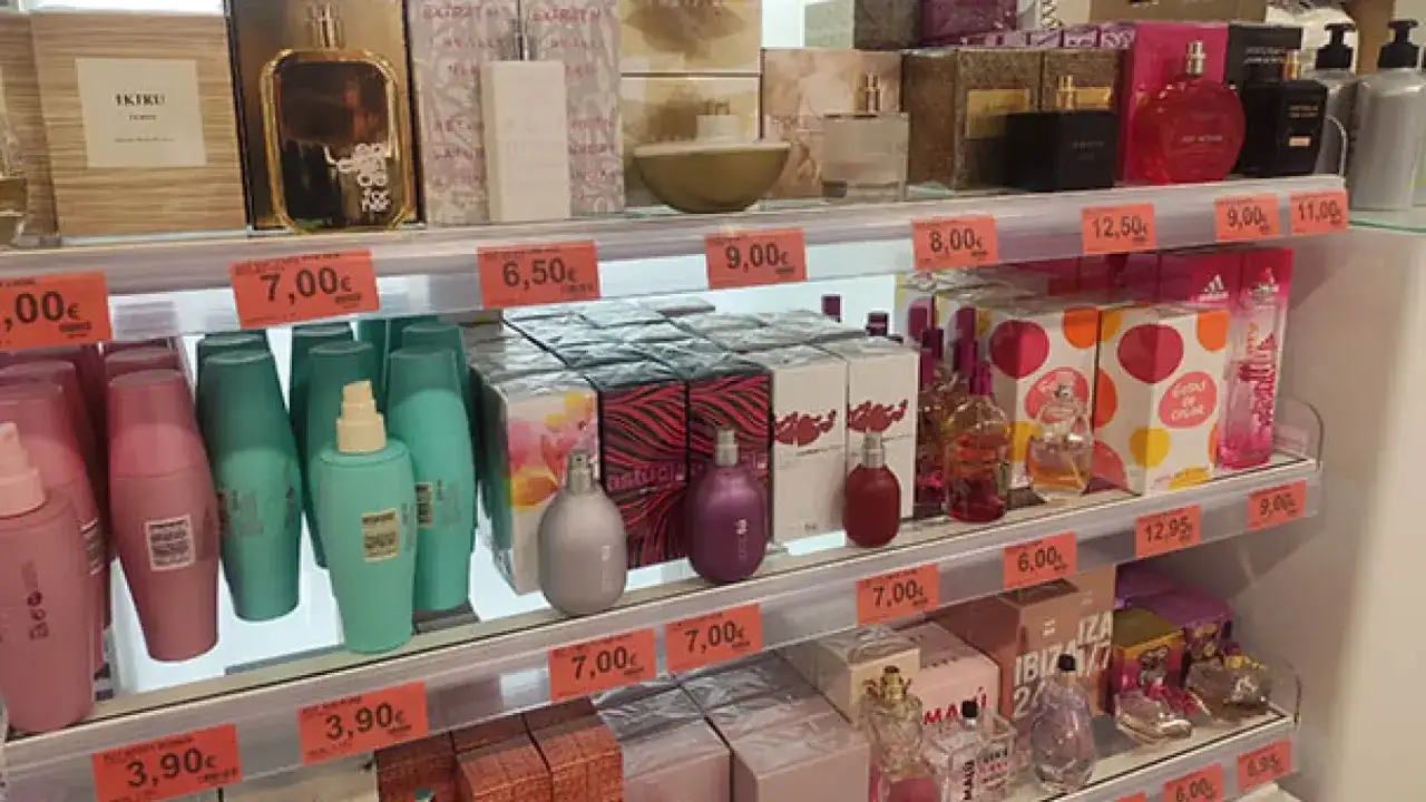 Estantería de Mercadona con perfumes y cosméticos. Una mujer busca su fragancia ideal, quizás una complicity woman.