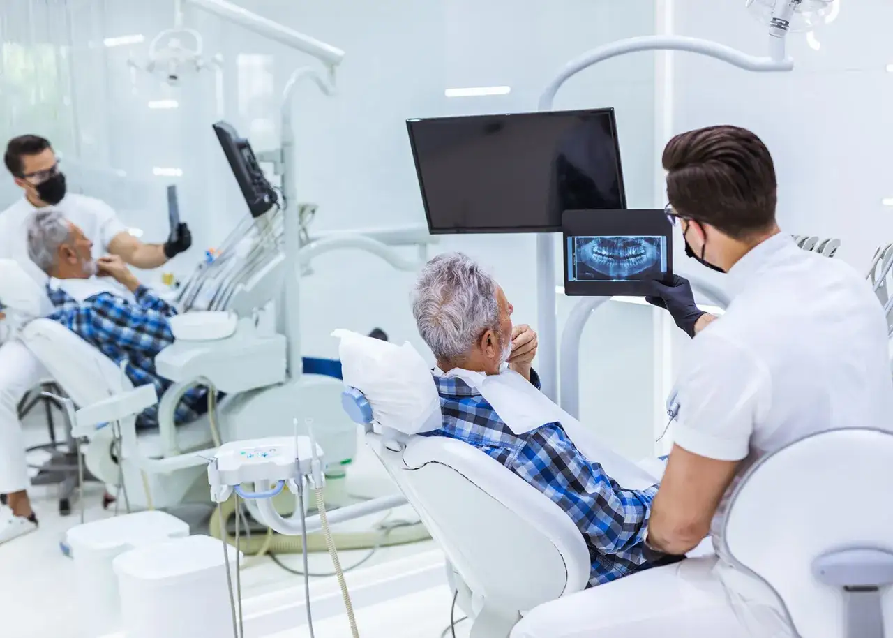 Dentysta omawia z pacjentem zdjęcie rentgenowskie zębów, planując skuteczne paradontoza leczenie.