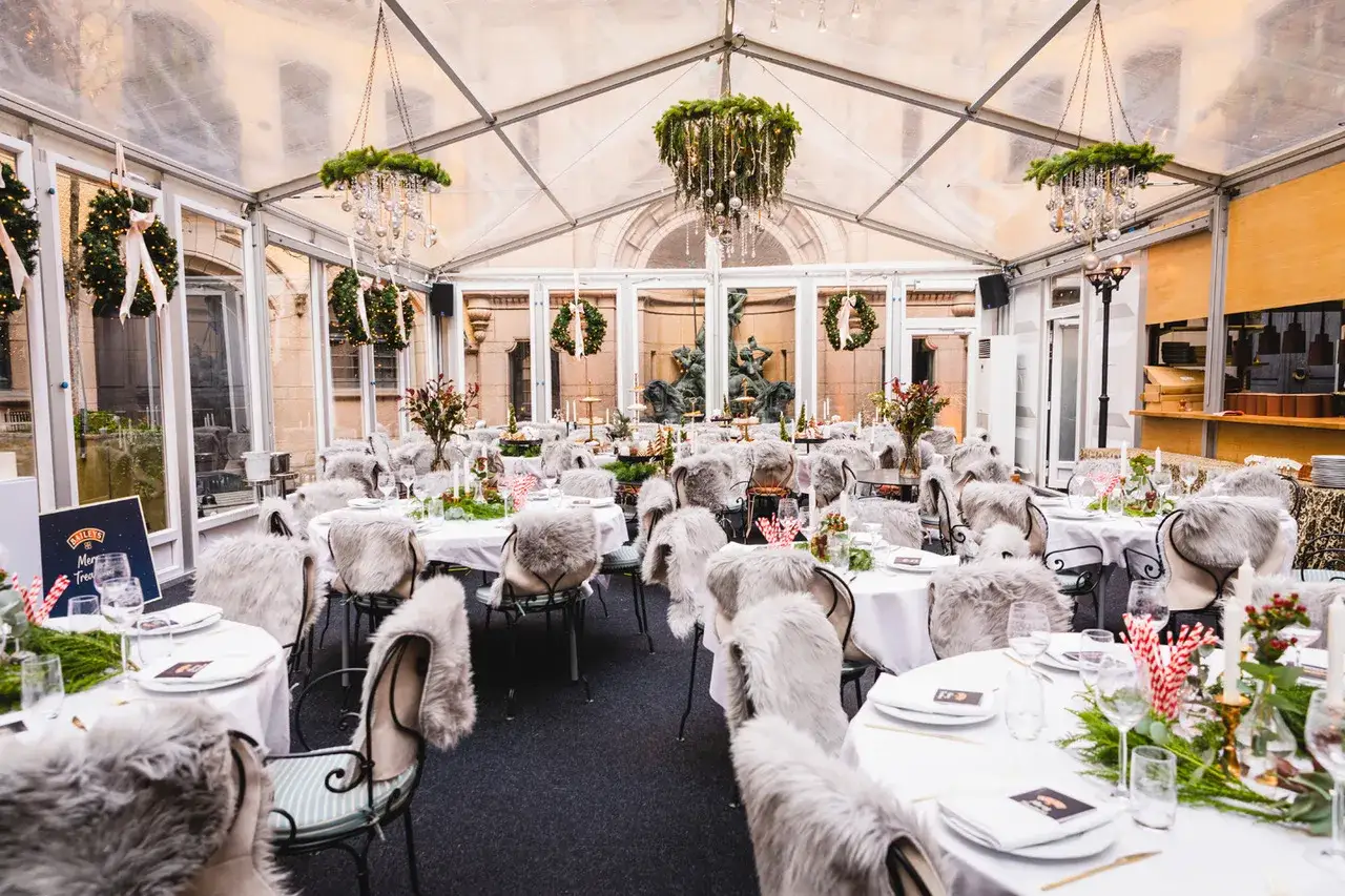 Vintermysig festlokal med juldekorationer och p&auml;lsbekl&auml;dda stolar. En perfekt plats f&ouml;r en julfest vid Hallwylska bar.