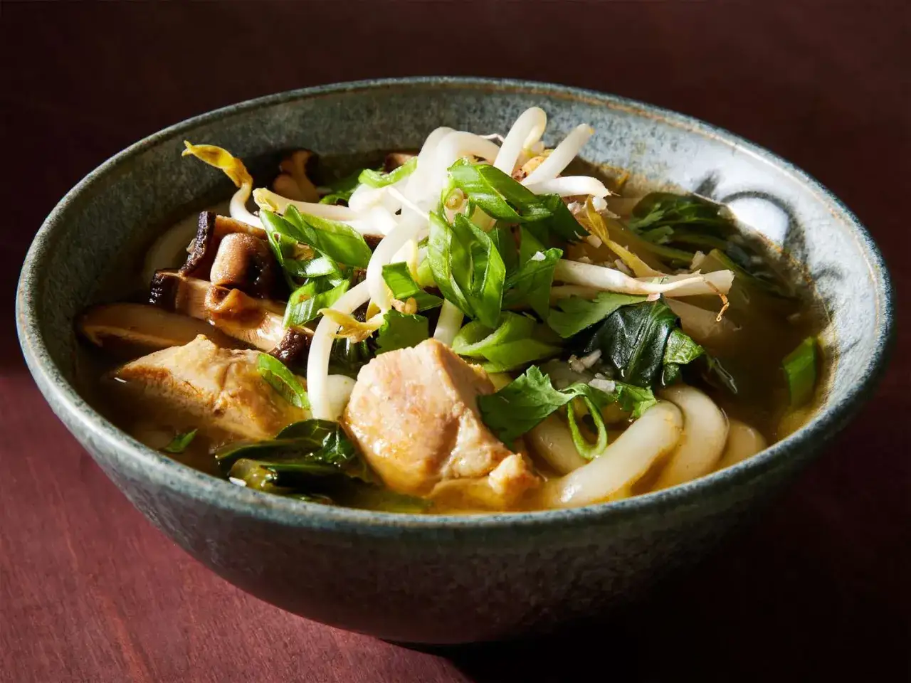 Miseczka z aromatycznym makaronem udon, kurczakiem, grzybami shiitake i kiełkami fasoli mung. Idealny makaron udon przepis na rozgrzewający posiłek.