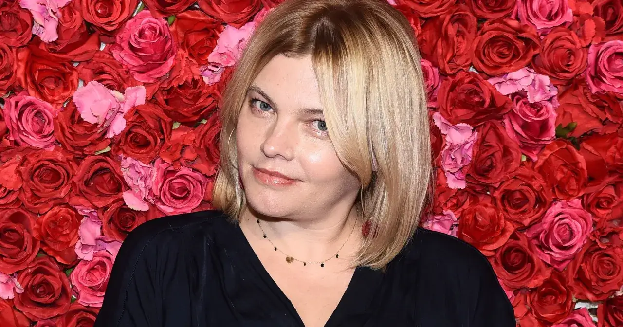 Ania Dąbrowska, wokalistka, na tle czerwonych róż. Jej piosenka