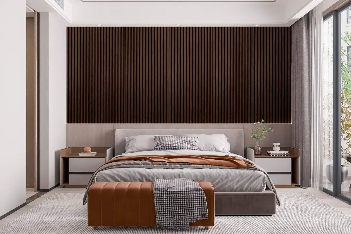 Modernt sovrum med en mörk träpanelvägg som ger sovrum panel inspiration. En bekväm säng med grå sängkläder och en brun pall framför.