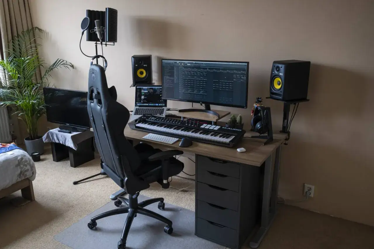 Bureau de musique avec clavier, moniteurs, micro et ordinateur. Tout le nécessaire pour devenir beatmaker et créer des sons.