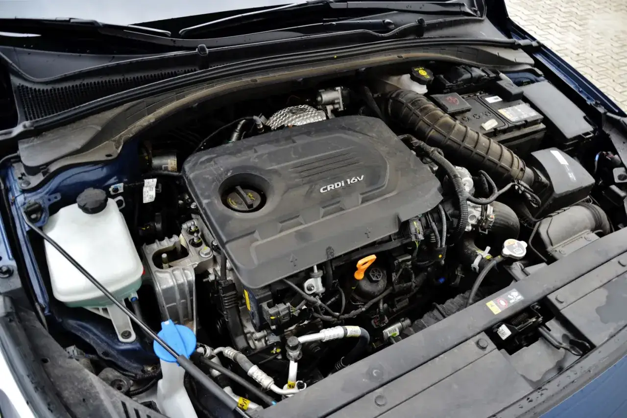 Silnik CRDi 16V w Hyundai i30 1.6 CRDi. Widoczny jest blok silnika, akumulator i elementy układu dolotowego.