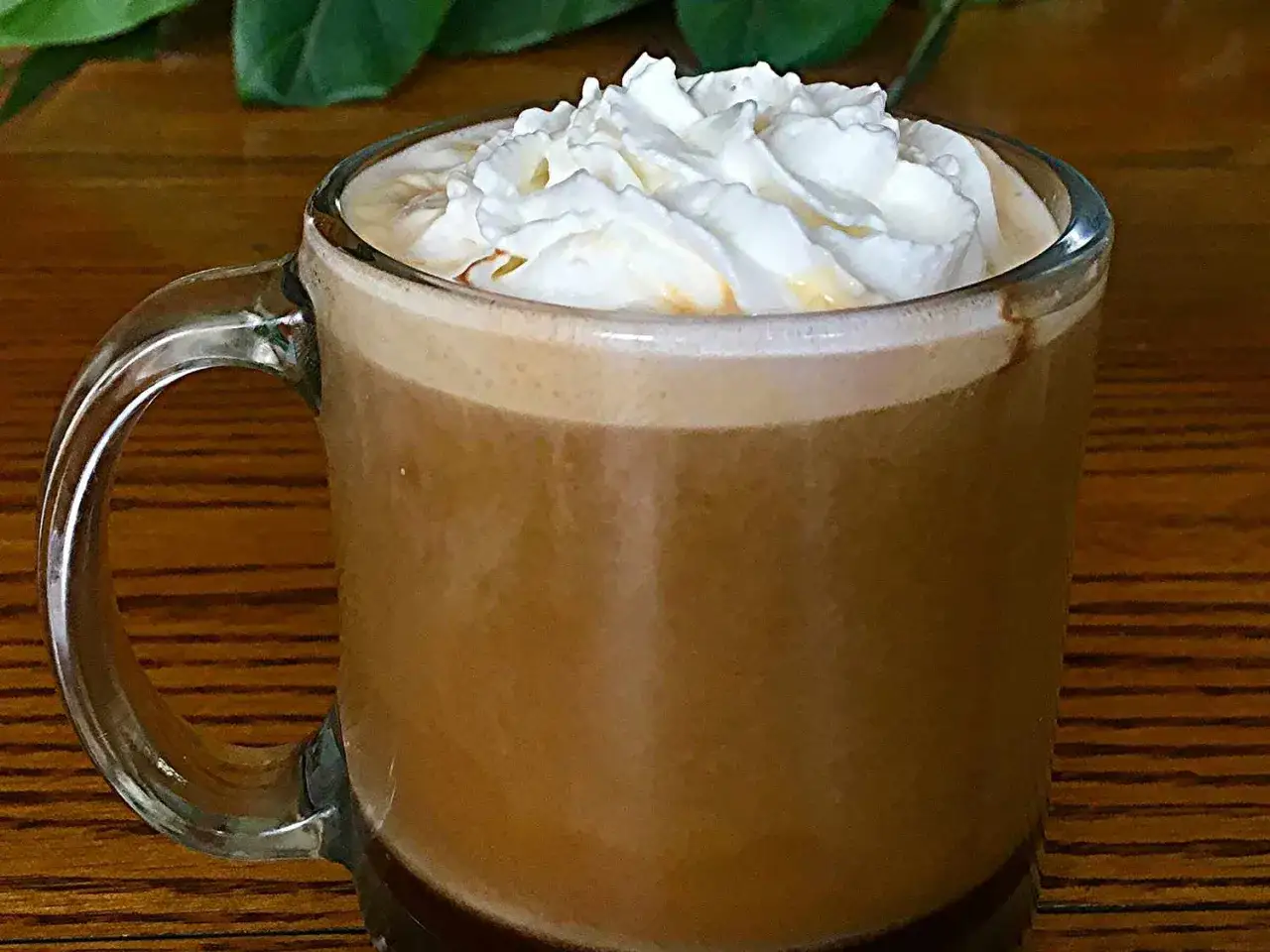 Pyszna kawa mocha z ekspresu, zwieńczona puszystą bitą śmietaną, kusi swoim aromatem.