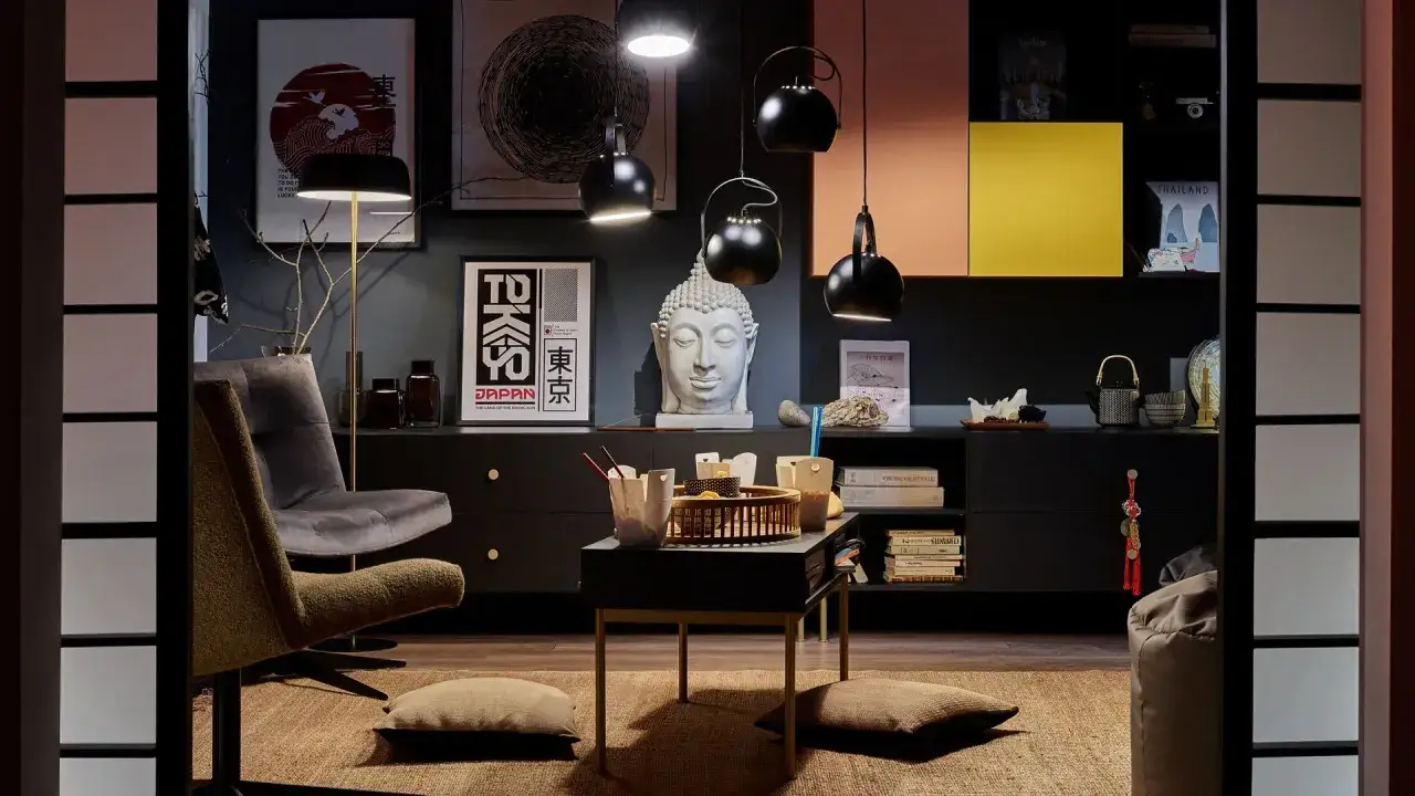Styl eklektyczny: szara sofa, stolik z azjatyckimi akcentami, rzeźba Buddy i plakaty z motywami Japonii tworzą unikalną przestrzeń.