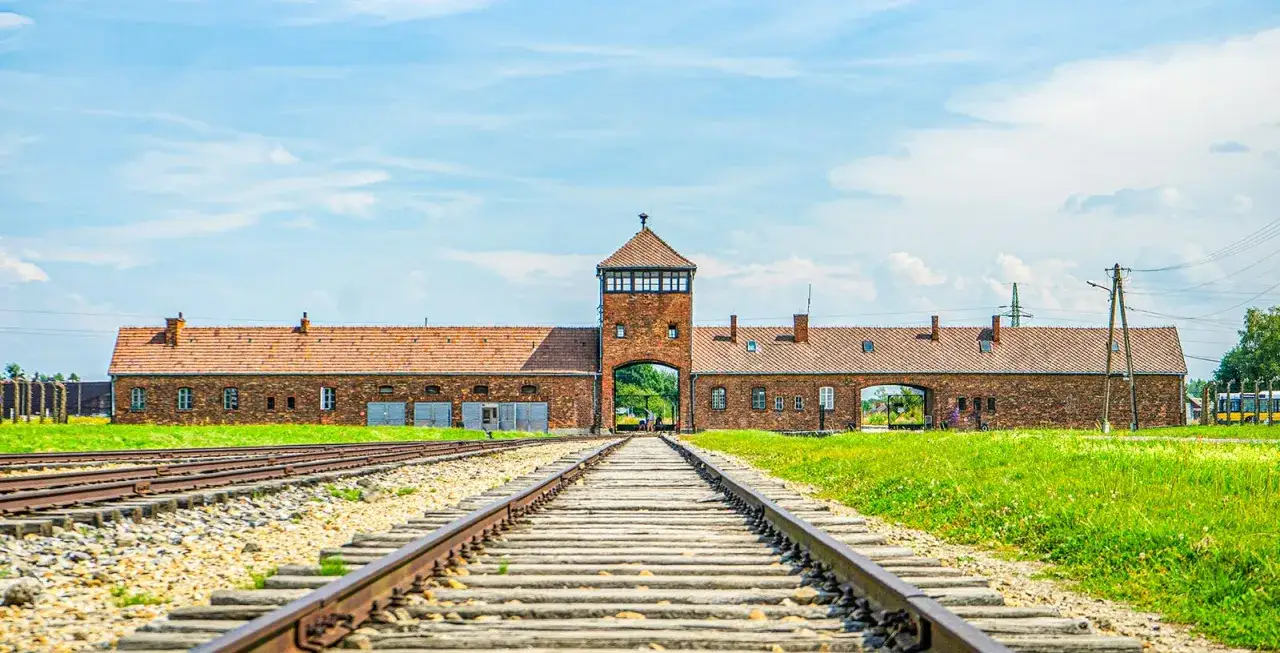 Brama obozowa Auschwitz, tory kolejowe prowadzące do niej. Miejsce pamięci, idealne na auschwitz zwiedzanie indywidualne.
