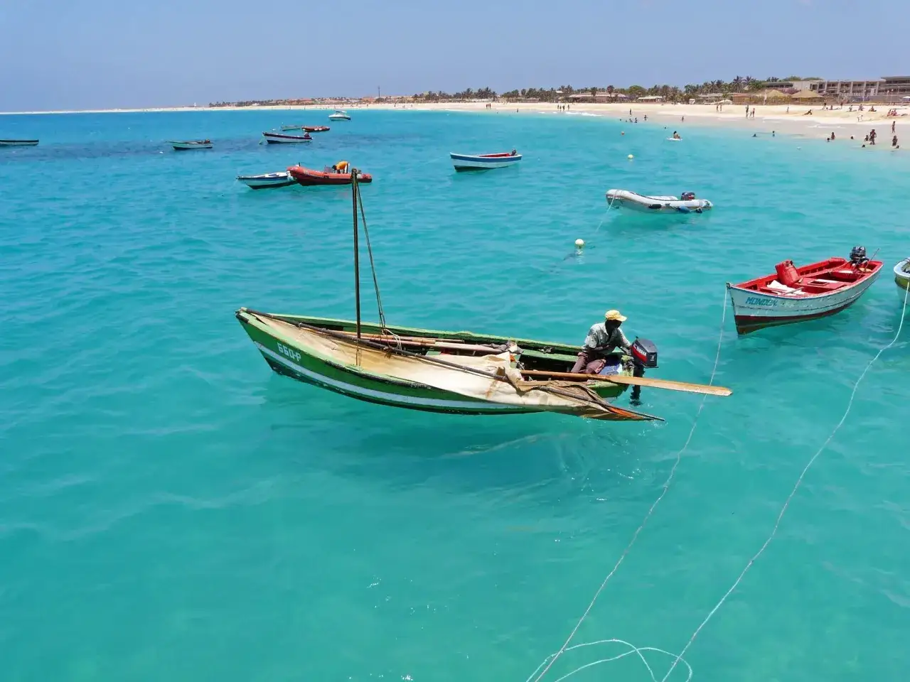P&ecirc;cheurs au Cap-Vert, une id&eacute;e de quoi faire : admirer les bateaux color&eacute;s sur l'eau turquoise, une sc&egrave;ne paisible.
