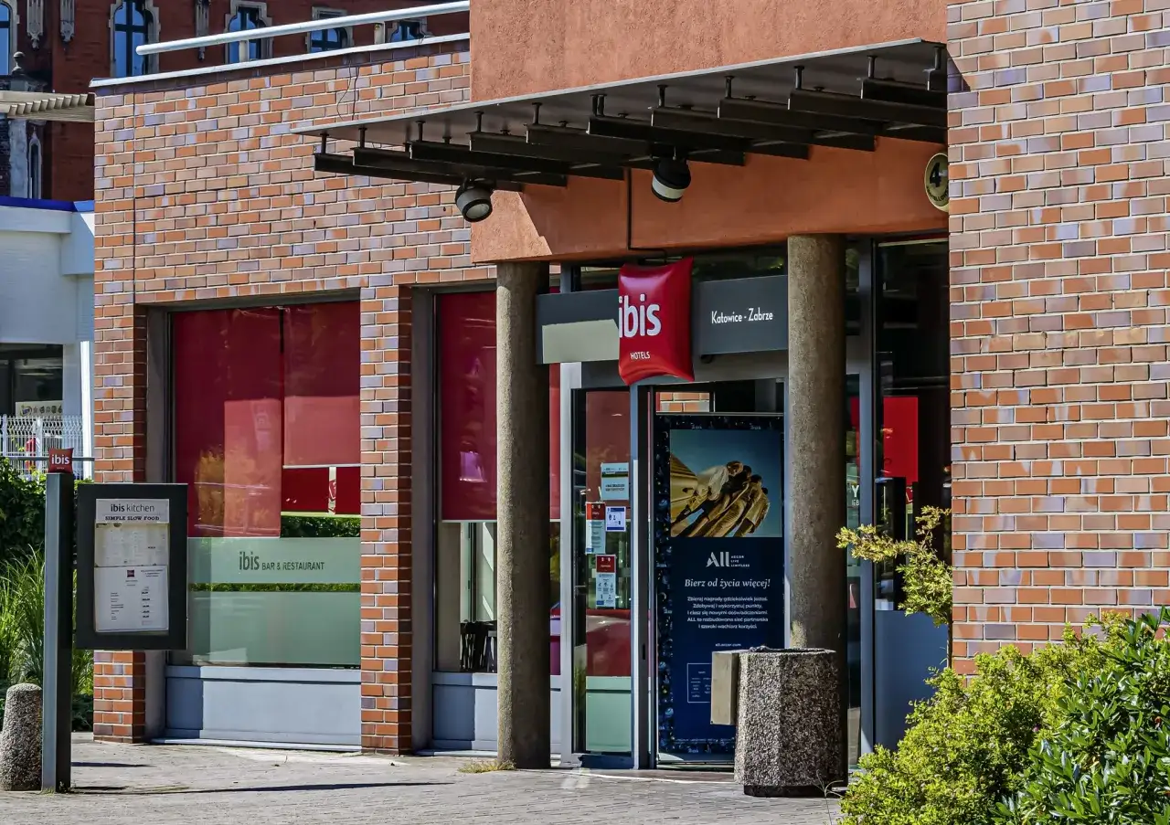 Wejście do Ibis Hotel Zabrze z czerwonym logo i napisem 