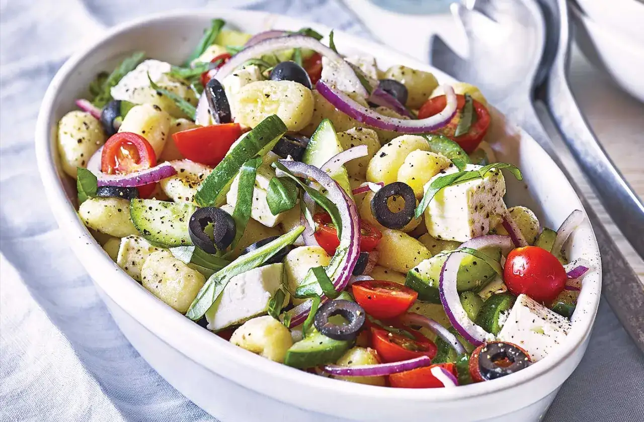 Ein bunter Gnocchi-Salat mit Tomaten, Gurken, roten Zwiebeln, Oliven und Feta.