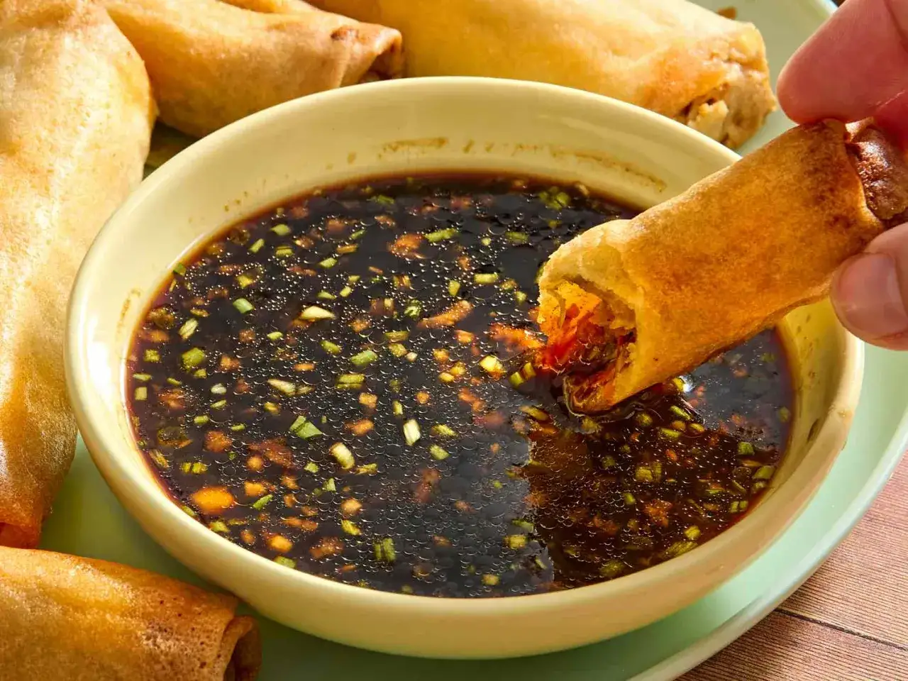 En frasig v&aring;rrulle doppas i en m&ouml;rk s&aring;s med gr&ouml;na bitar, perfekt med lite sweet chili s&aring;s.