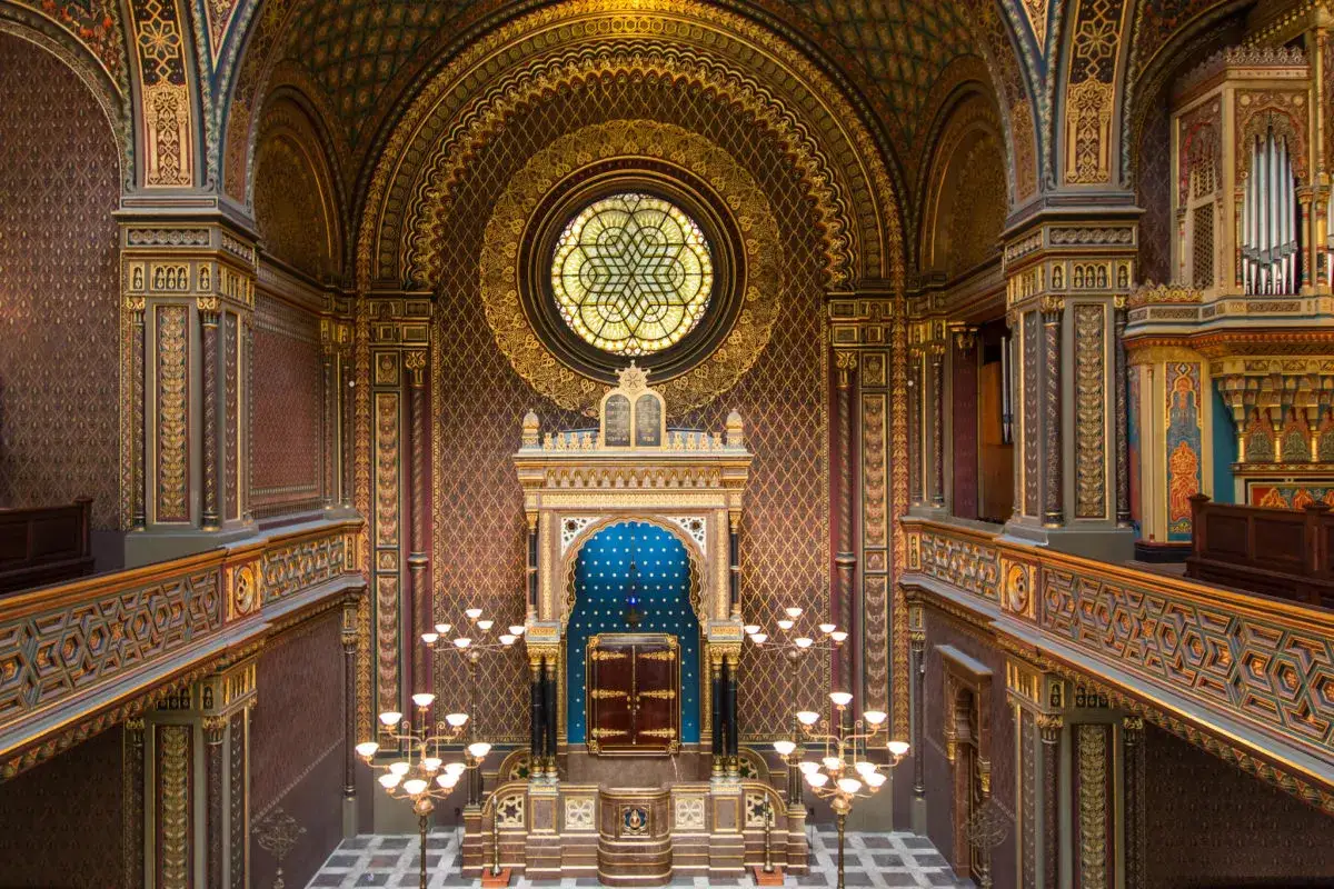 Intérieur orné de la synagogue espagnole de Prague, avec son arche bleue, sa fenêtre circulaire et ses lustres dorés.