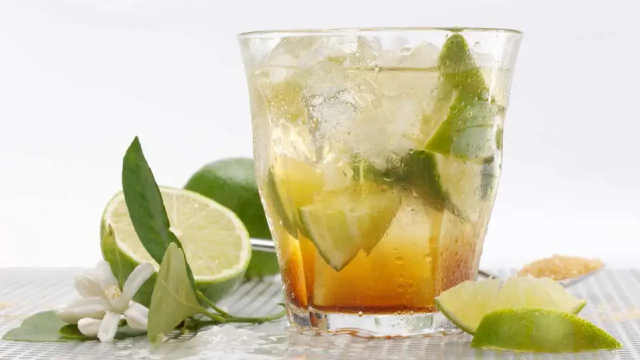 Erfrischender caipirinha alkoholfrei mit Limettenstücken und Eiswürfeln, garniert mit Limettenblüten.
