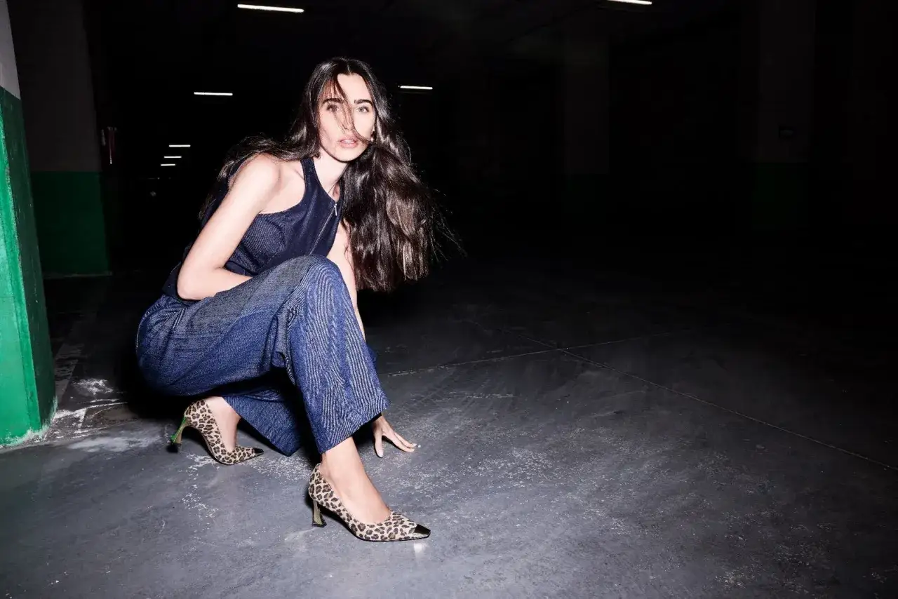 Donna con pantaloni larghi alla caviglia e décolleté leopardate. Un'idea su che scarpe mettere con pantaloni larghi alla caviglia.