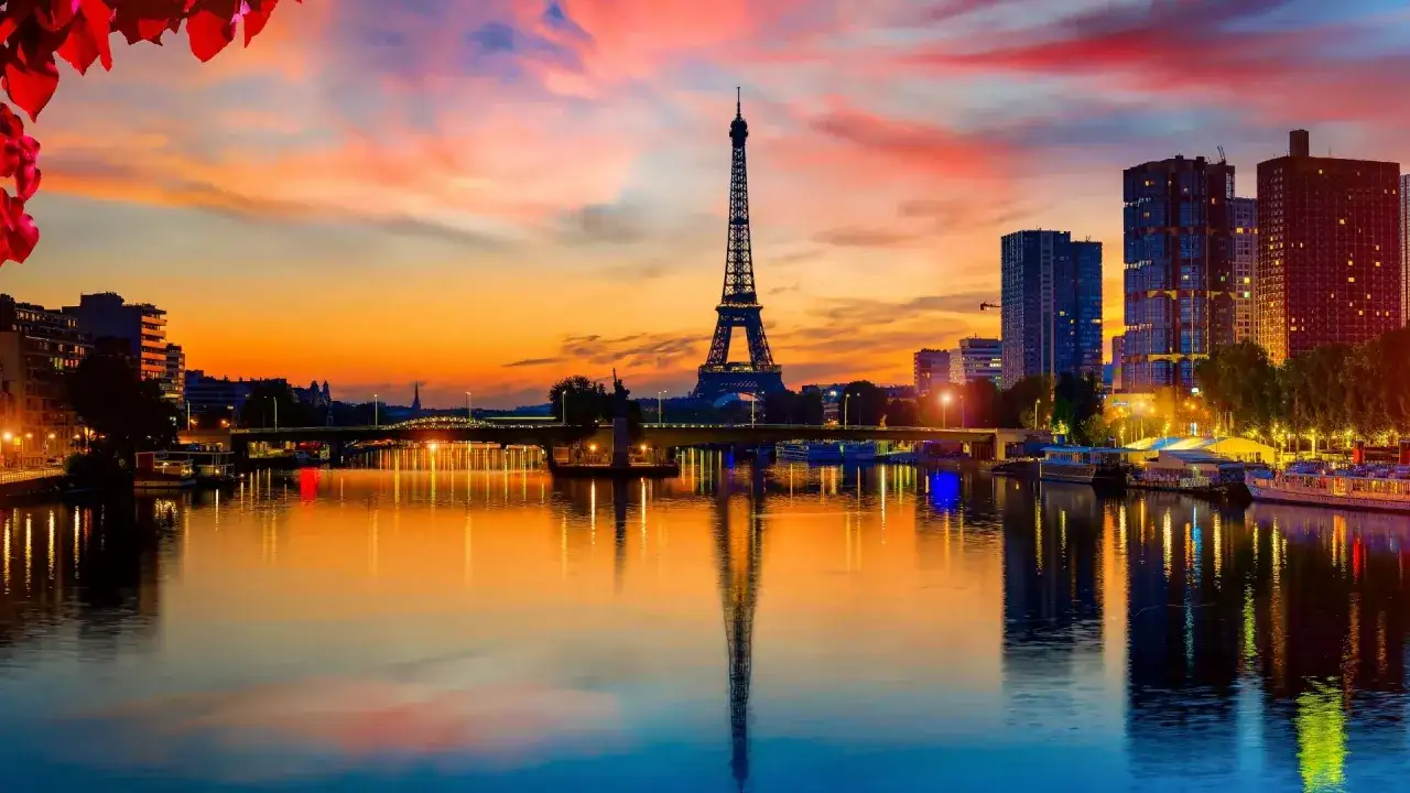 La Tour Eiffel se reflète dans la Seine, sous un ciel aux couleurs flamboyantes. Paris ce soir, une vision magique.