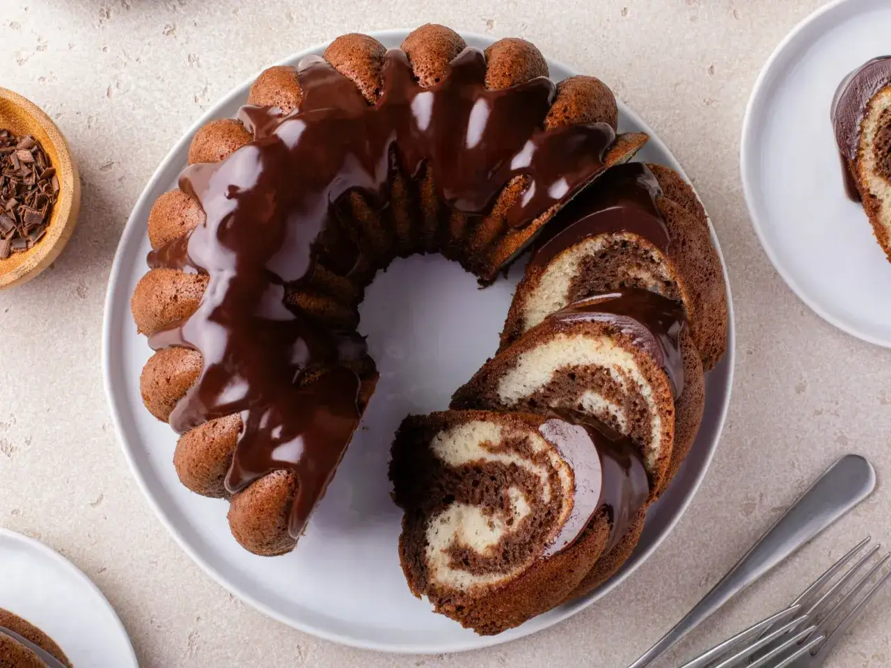 Wilgotna babka wielkanocna dwukolorowa, polana czekoladą, z widocznymi plastrami ciasta.