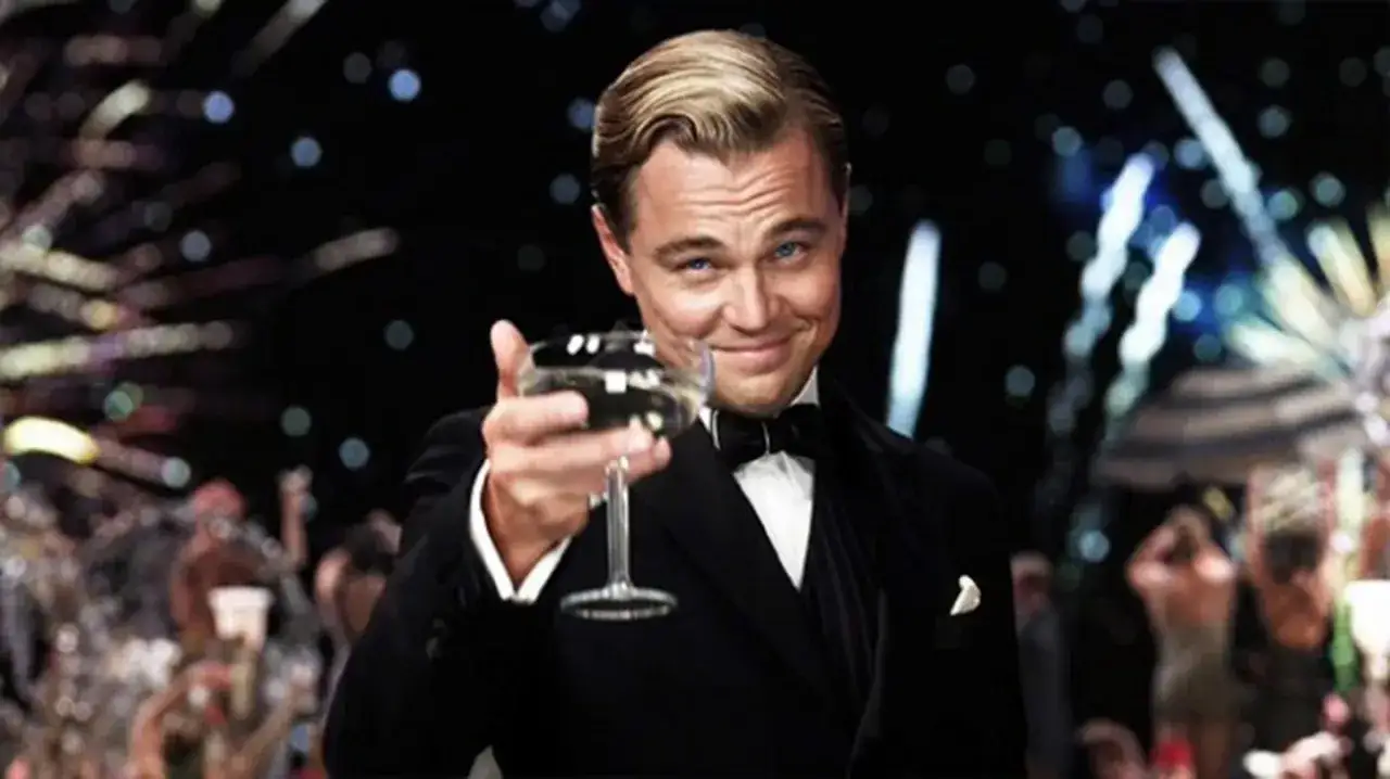 Leonardo DiCaprio w garniturze wznosi toast, świętując swój długo wyczekiwany Oscar.