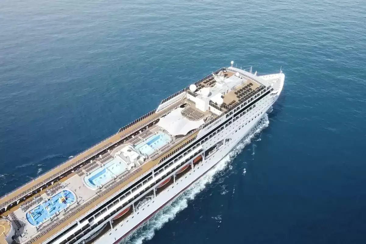 La MSC Lirica, con la sua impressionante lunghezza, solca le acque blu, mostrando ponti con piscine e lettini.