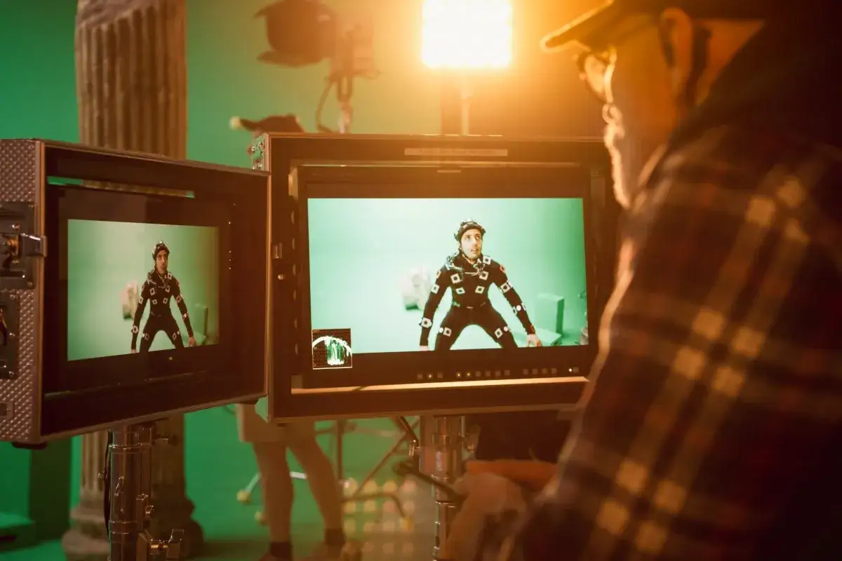 Operator obserwuje na monitorze postać w stroju do motion capture, co jest kluczowe dla zrozumienia cgi meaning.