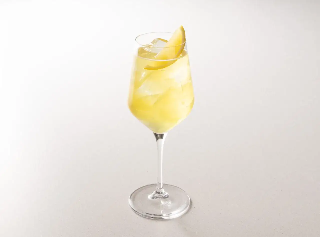 Un rinfrescante limoncello spritz, con ghiaccio e una fetta di limone, pronto per essere gustato.